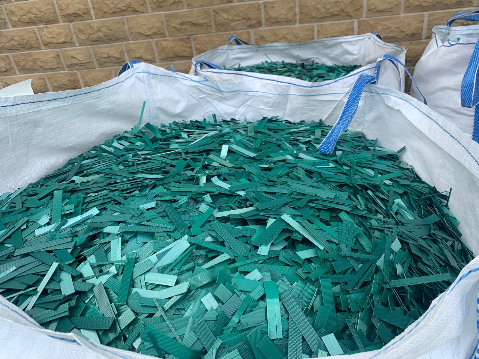 Green plastic off-cuts collected in a bulk bag